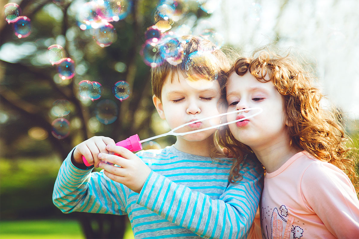 Kinder und Seifenblasen im Freien